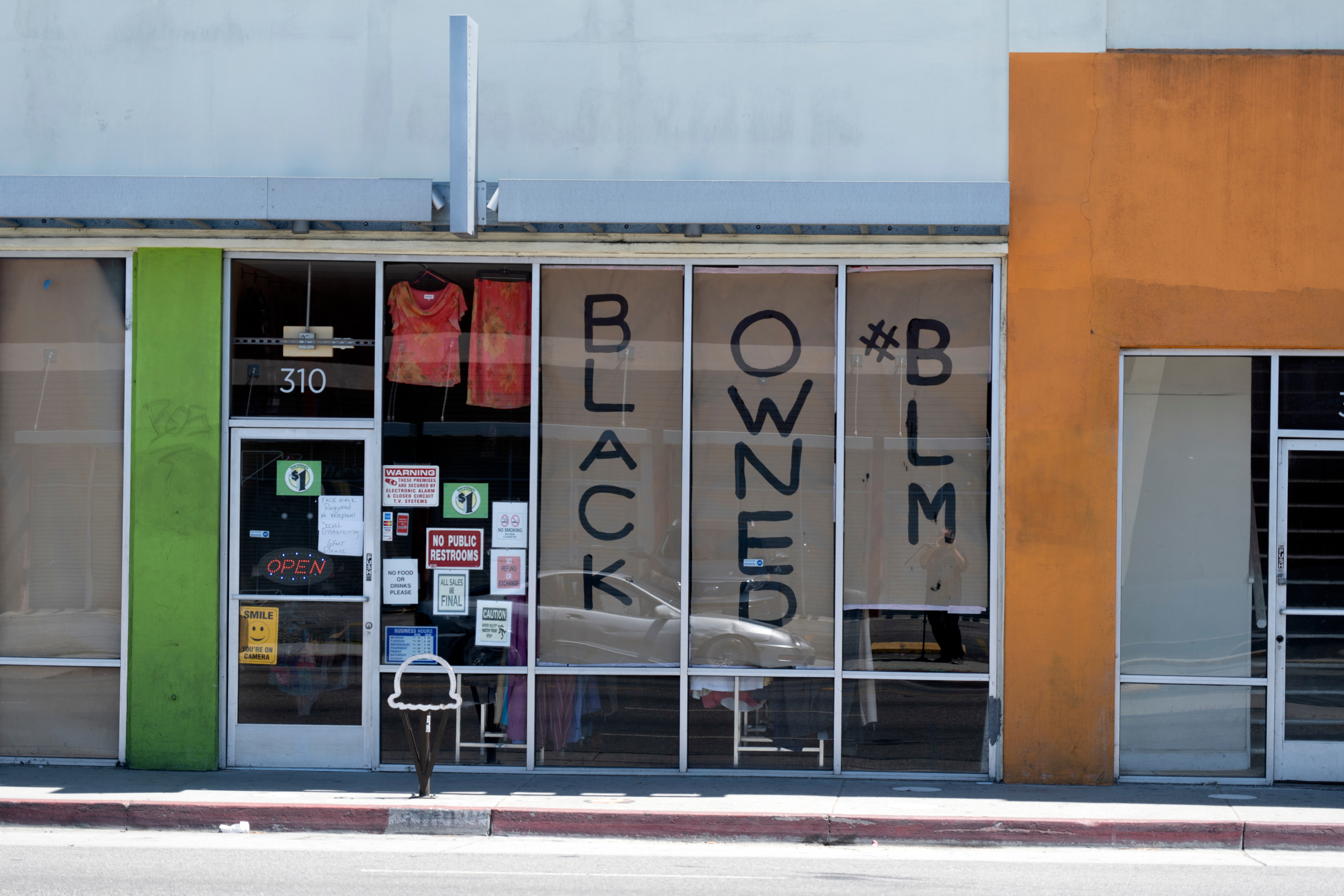 store front with signs in the windows stating "Black Owned #BLM"