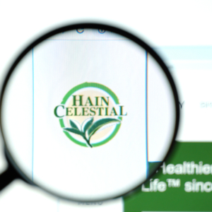 blurred magnifying glass up close looking at a logo for Hain Celestial in focus through the lens