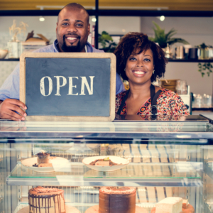 Black cafe owners with open sign